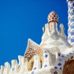 Tejado de mosaico ornamentado con motivos geométricos de colores contra un cielo azul brillante.