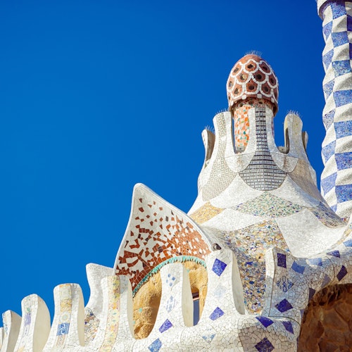 Tejado de mosaico ornamentado con motivos geométricos de colores contra un cielo azul brillante.